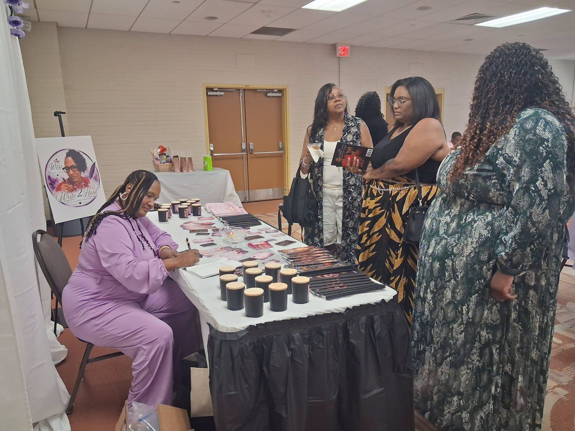 Roslyn Thompson signing books for guests at the Write 2 Heal table.