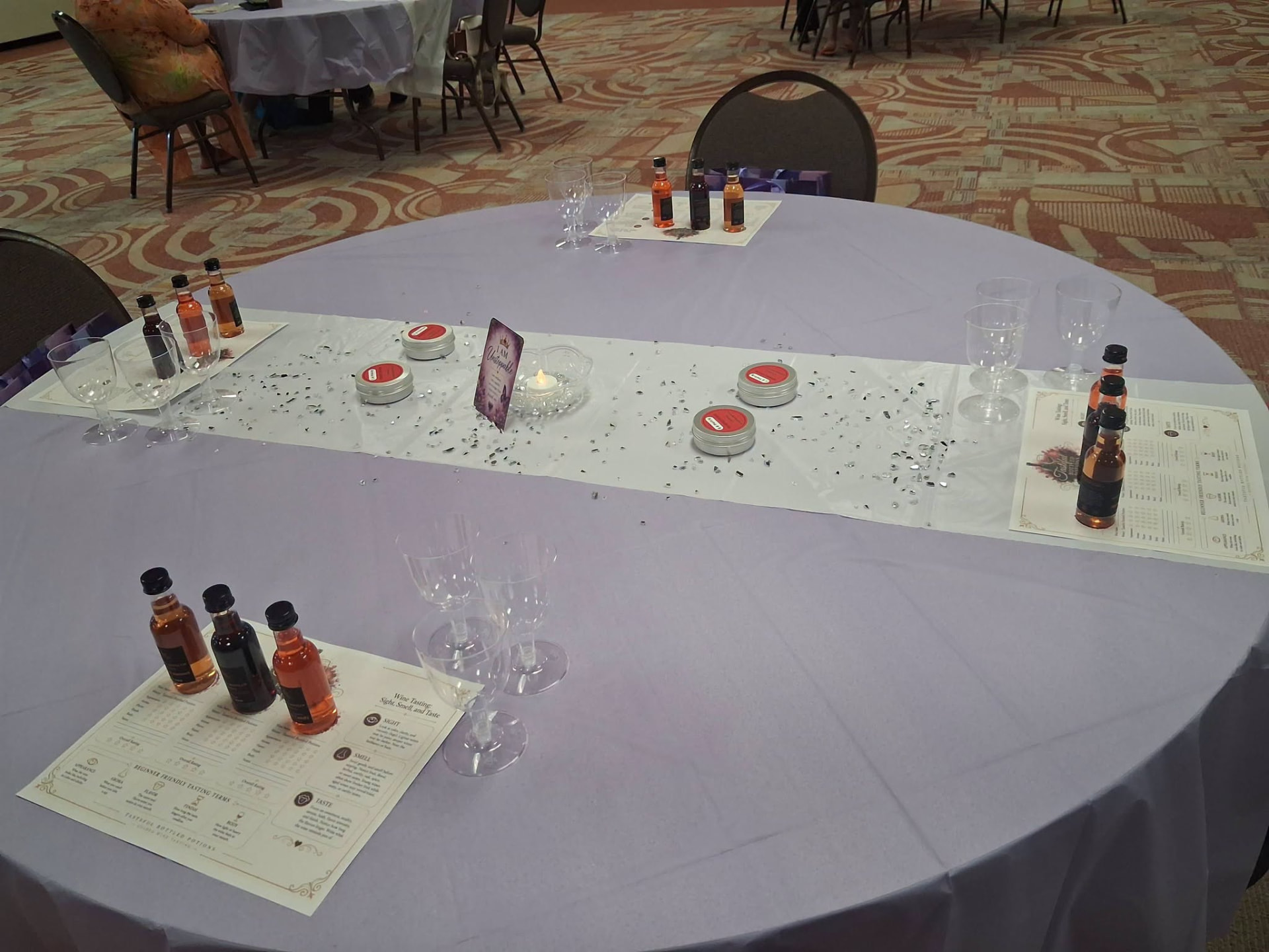 A guest table set with wine tasting flights, tasting notes, and candles.